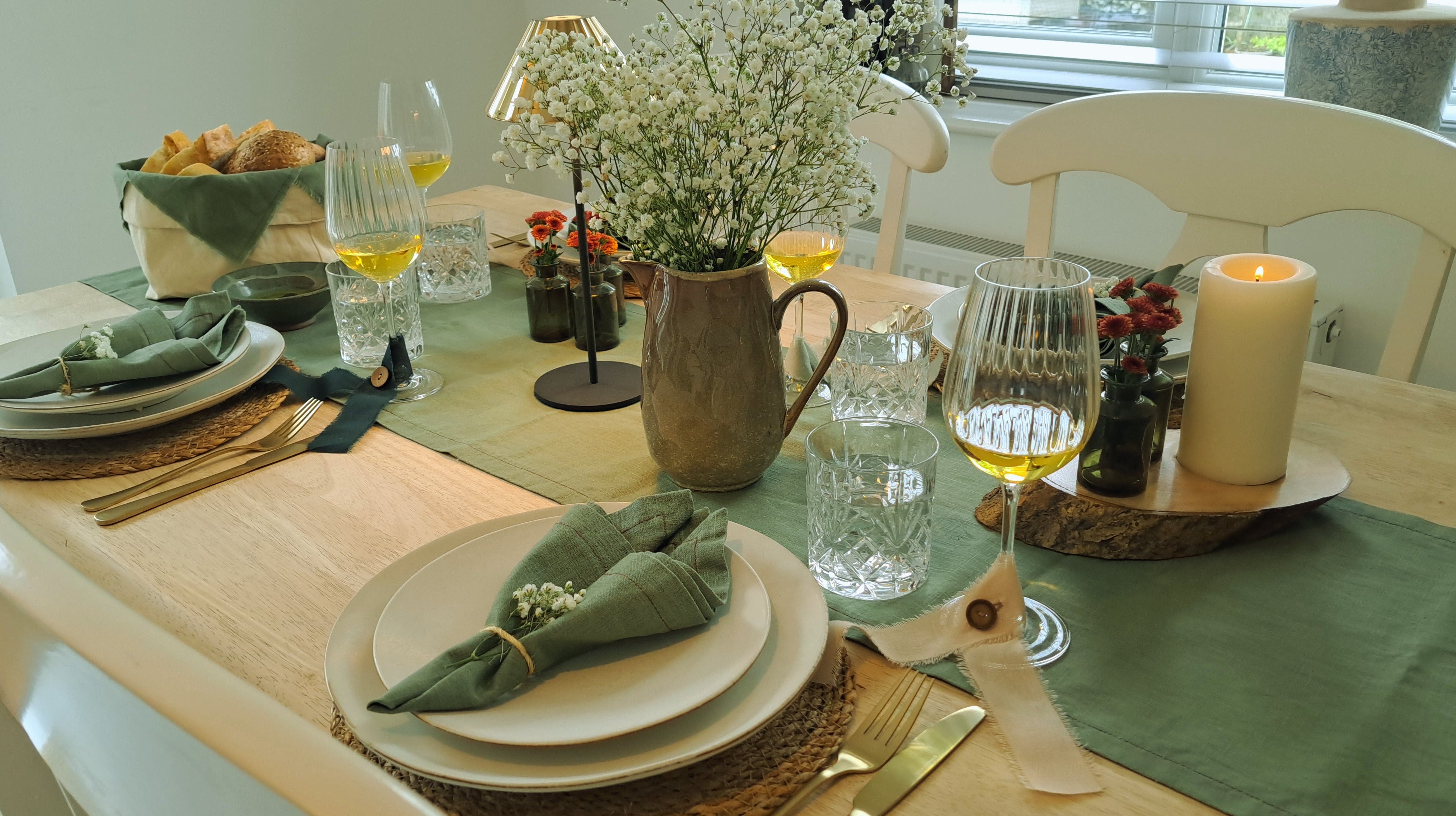 Dining table set for a meal with plates, glasses, and decorative items.