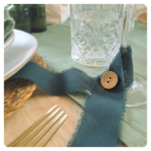 Green decorative ribbon glass marker in a table setting.